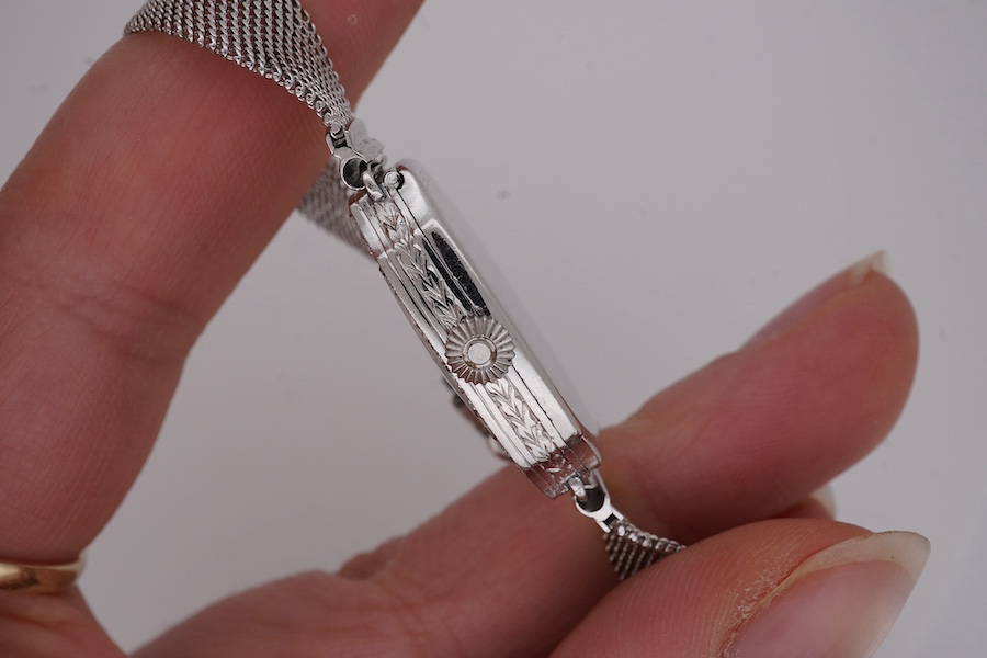 A lady's mid 20th century Swiss white metal(platinum mark) and diamond set cocktail watch with 'tumbling' Arabic numeral dial, on a 9ct white metal mesh link bracelet, case diameter 16mm, overall length 16cm, gross weigh